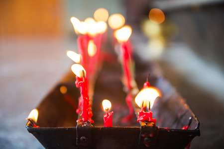 burning red candle in temple, prayerの写真素材