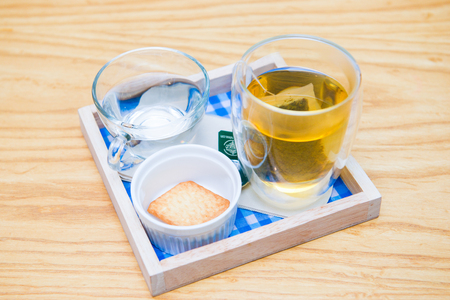 Set of hot tea and biscuit on wooden plate in cafe, beverageの写真素材