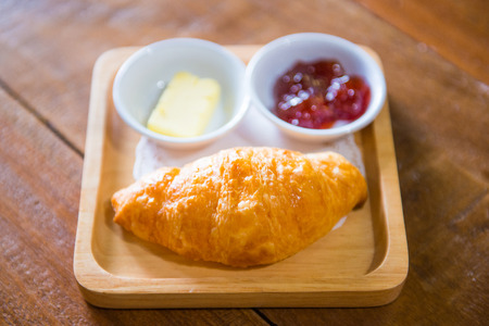 Fresh croissant on wooden plate, bakeの写真素材
