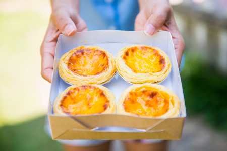 Freshly baked delicious egg tart on paper box, dessert