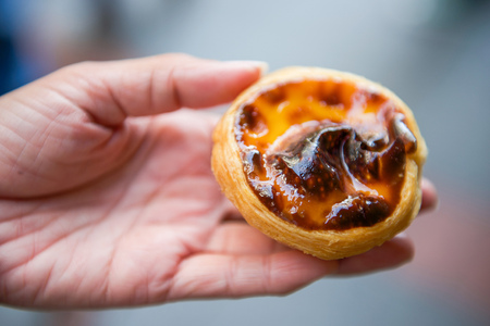 Sweet egg tart custard pie on woman's hand, dessert