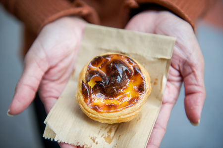 Sweet egg tart custard pie on woman's hand, dessert