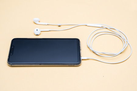 black smartphone and white earphone,electronic