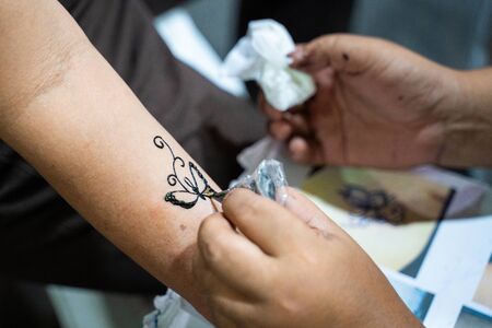 artist drawing butterfly on arm Henna paint,Hennaの写真素材