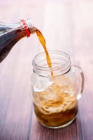 pouring cola sparkling water into a glass,sodaの写真素材