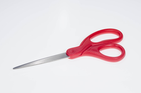A pair of closed red scissors on white background.の写真素材