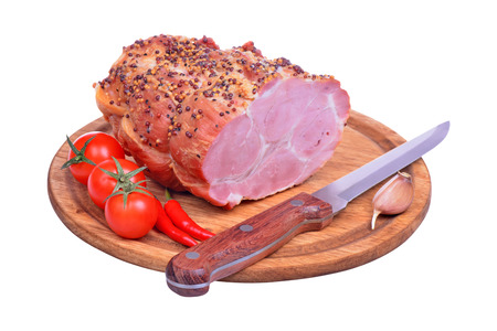 Baked pork neck, tomatoes, peppers, garlic and knife isolated on white backgroundの写真素材