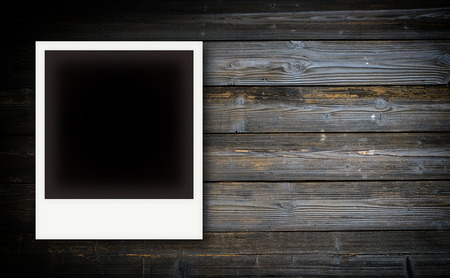 Vintage photo frames on wooden board background textureの写真素材