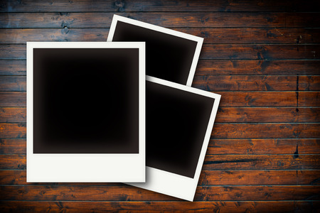 Photo frames on wooden board background texture
