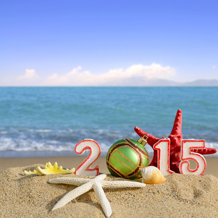 New year 2015 sign with seashells, starfish and christmas ball on a beach sand