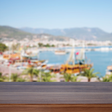 Empty wooden table. In the background blurred boats and yachts in the bay in sunny dayの写真素材