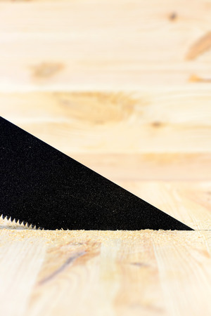 Workplace and tools of a carpenter or builder-hacksaw sawing wood surfaceの写真素材