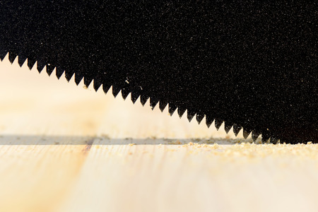 Workplace and tools of a carpenter or builder-hacksaw sawing wood surfaceの写真素材