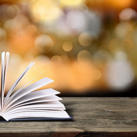 Open book with bokeh light on dark abstract background