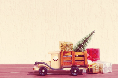 Christmas background.Toy truck carries gifts and a Christmas tree. Photo in vintage styleの写真素材