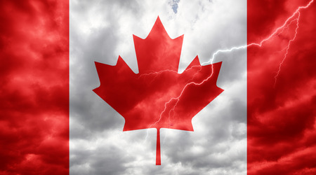 Canadian flag against dark sky, clouds and lightningの写真素材