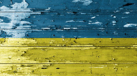 Ukraine flag on wood texture background with old paint peelsの写真素材