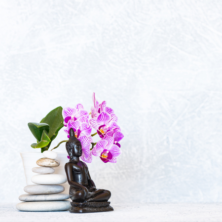 Buddha, pyramid of pebbles and orchid flower as zen backgroundの写真素材