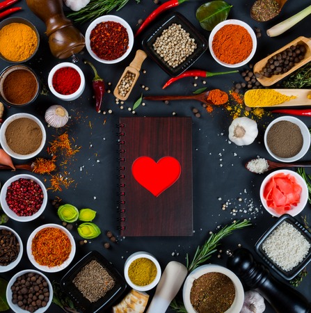 Large set of spices, herbs, vegetables and notebook on black backgroundの写真素材