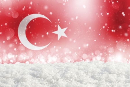Defocused Turkey flag as a winter Christmas background with falling snow, snowdrift and bokehの写真素材