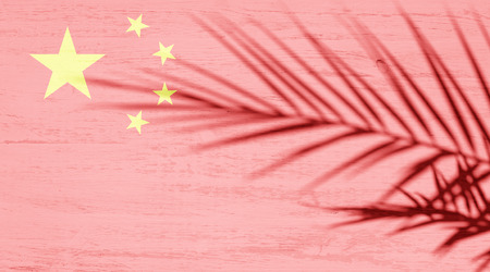 China flag and shadow of palm branch on white wooden surfaceの写真素材