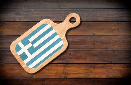 Concept of Greek cuisine. Cutting board with a Greece flag on a wooden backgroundの写真素材