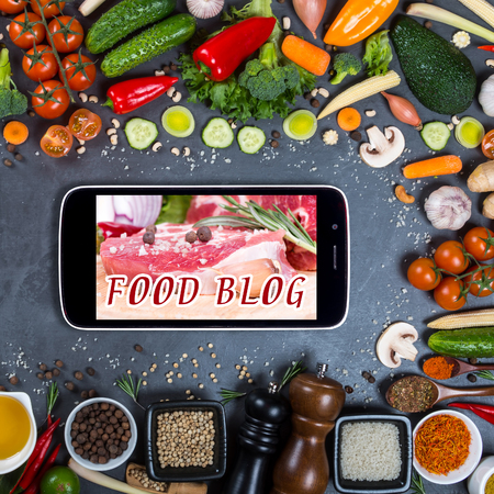 Food blog concept. Big set of vegetables, spices and smartphone on a black backgroundの写真素材