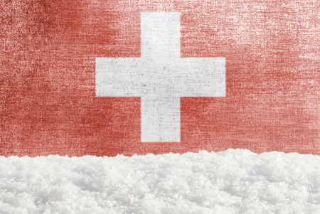 Winter grunge background with snowdrift and Swiss flag in the backdropの写真素材