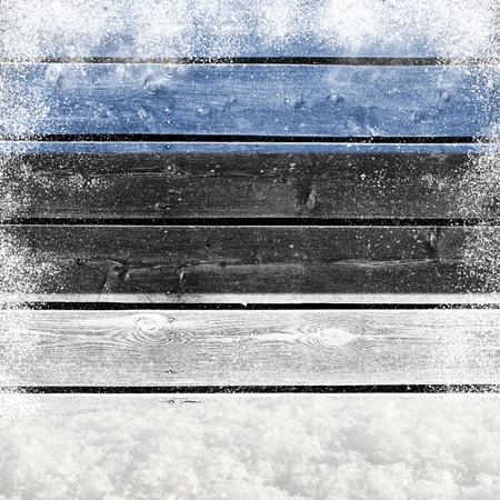 Winter background with wooden wall, falling snow, snowdrift and Estonian flagの写真素材