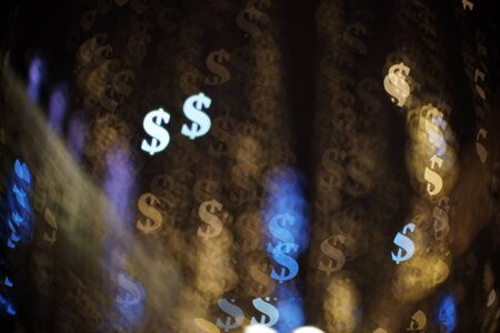 Dollar bokeh lights on city streets. Abstract financial background with many dollar symbols