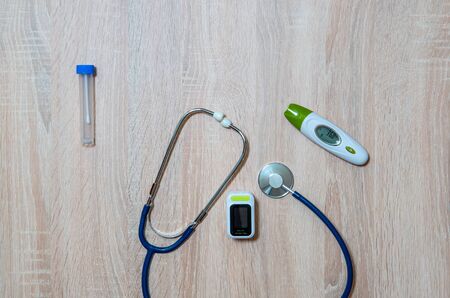 Doctor's equipment for taking tests for infection with the virus Covid-19-stethoscope, thermometer, oximeter and test tubeの写真素材