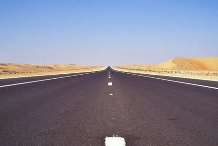 Long straight road through sandy desert Arab Emiratesの写真素材