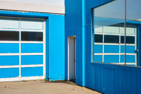 Blue and white Garage building with mirrored windows and reflectionの写真素材