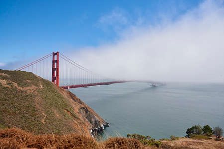 Bright red Golden Gate Bridge half covered in mist from the north sideの写真素材