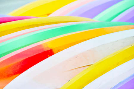 Detail of two rows of colorful stacked surfboards with yellow and white and greenの写真素材