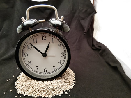 classic black alarm clock on black background with copy paste area god for quote,advertisement