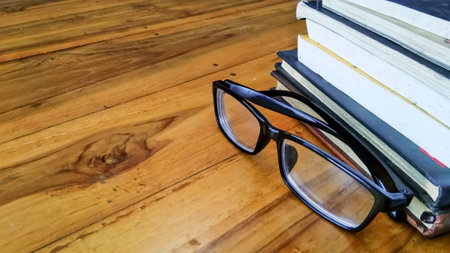 glasses and books on a wooden table with copy space