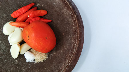 the ingredients for making a typical Indonesian chili sauce consisting of garlic, chilies, tomatoes, sugar and saltの写真素材