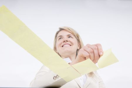 Check off the list: woman placing reminder notes in check shape on transparent surface の写真素材