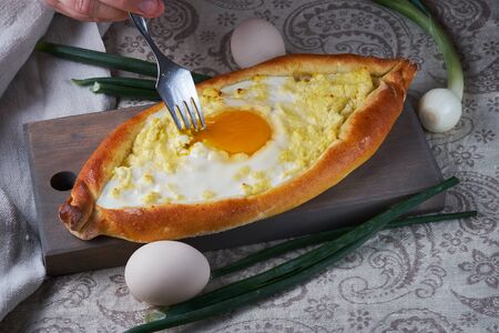 Ajar traditional khachapuri. National Georgian cuisine. Khachapuri closeup. The hands of man in the frame.の写真素材