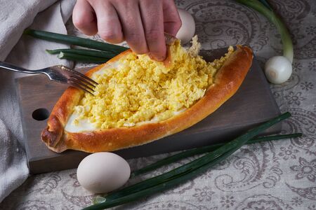 Ajar traditional khachapuri. National Georgian cuisine. Khachapuri closeup. The hands of man in the frame.の写真素材