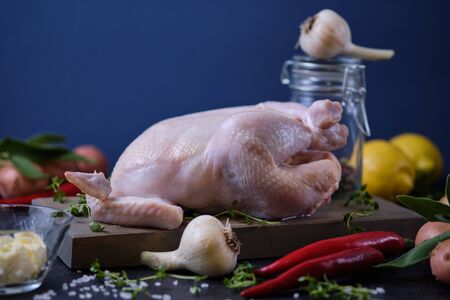 The process of cooking chicken with herbs, spices and lemon in the oven. On the table are the products that are needed for cooking.の写真素材