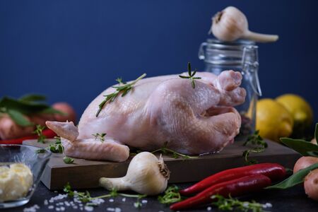 The process of cooking chicken with herbs, spices and lemon in the oven. On the table are the products that are needed for cooking.の写真素材