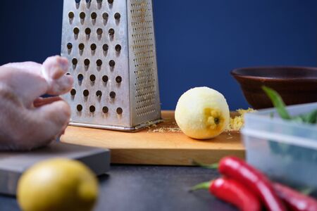 The process of cooking chicken with herbs, spices and lemon in the oven. On the table are the products that are needed for cooking.の写真素材