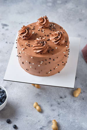 Chocolate sponge cake stuffed with salted caramel and peanuts. Cake with cream cheese chocolate cream.の写真素材