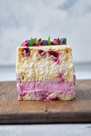 A cutaway berry sponge cake. Cake with cream cheese mousse, condensed milk and blackberry puree. Sponge cake with currant berries.の写真素材