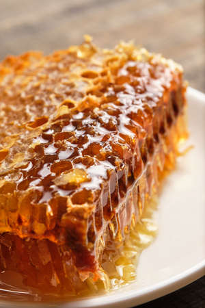 Honeycomb close-up. Fresh honey from the field on an old wooden table.の写真素材
