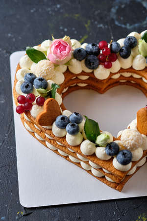 Honey cake with fresh blueberries, herbs and cream cheese cream. Dessert for a loved one. Heart cake.の写真素材