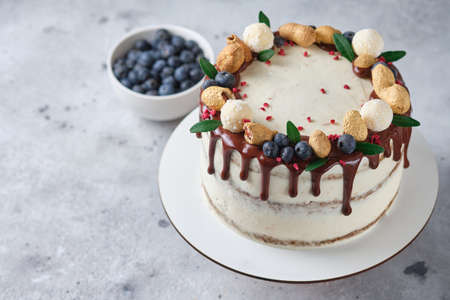 Honey sponge cake with salted caramel and peanuts. Cake with cream cheese cream and peanut butter. Delicious natural and beautiful festive dessert.の写真素材