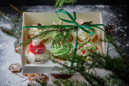 New Year's gift sets of sweets. A box of cupcakes as a Christmas present. Cakes with cream cheese cream and peanut-caramel filling.の写真素材